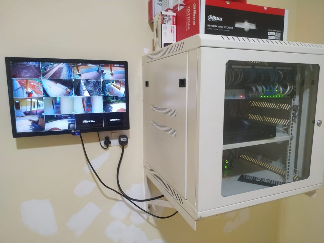 CCTV control room with live camera feeds and NVR cabinet